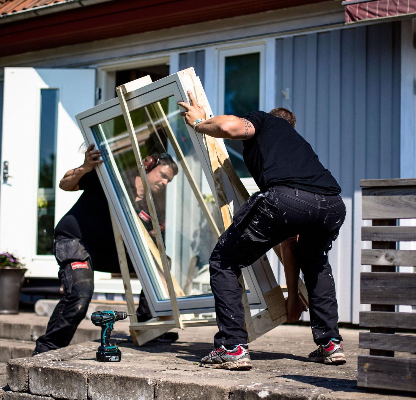 två killar ställer ner ett fönster